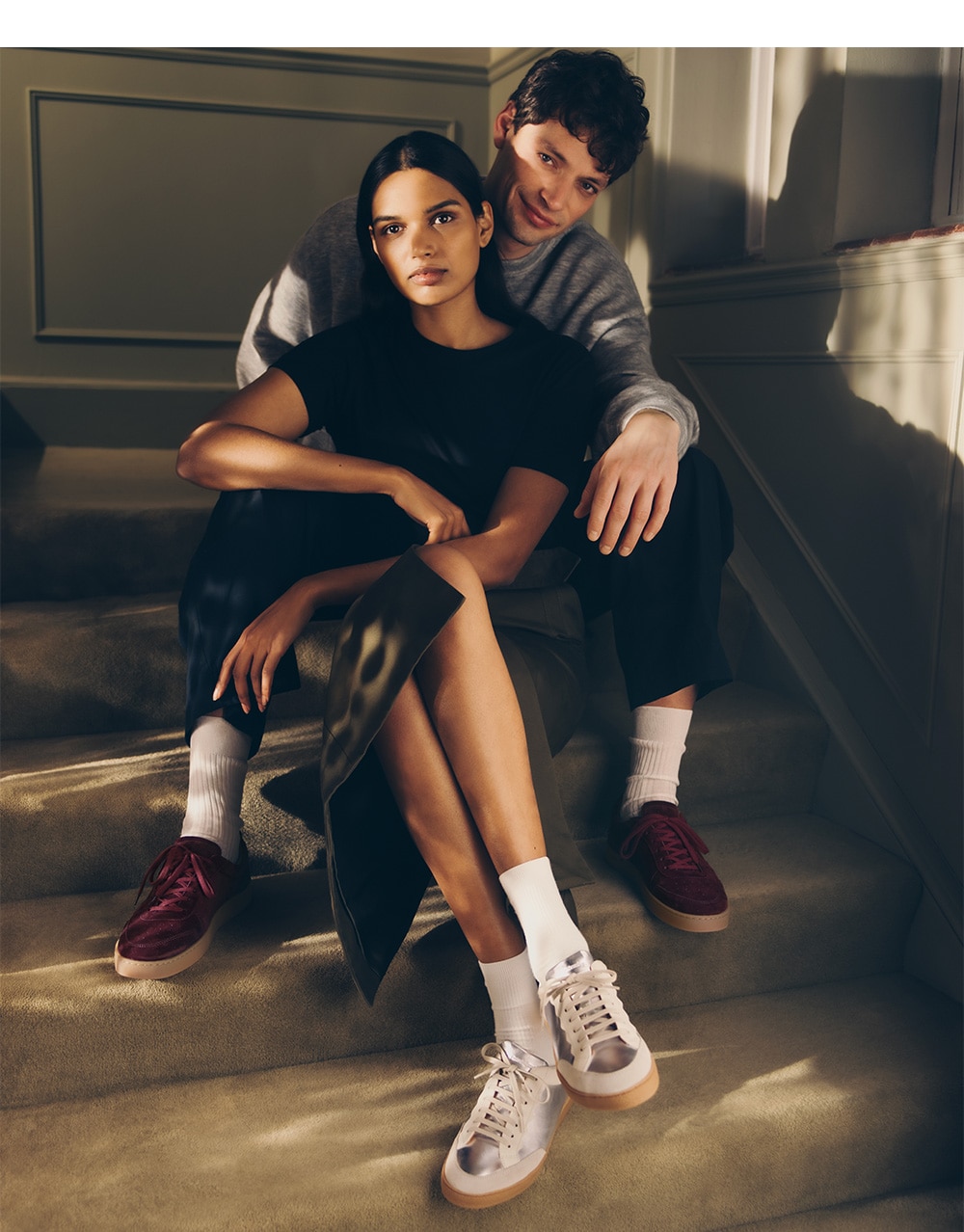 model couple sitting on stairs wearing spring 24 sneakers