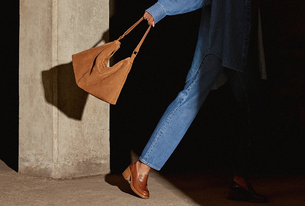 Women wearing brown Russell and Bromley shoes and holding brown Russell and Bromley bag